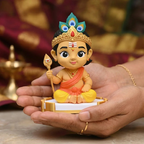 Small figurine of a deity held in hands with a blurred background